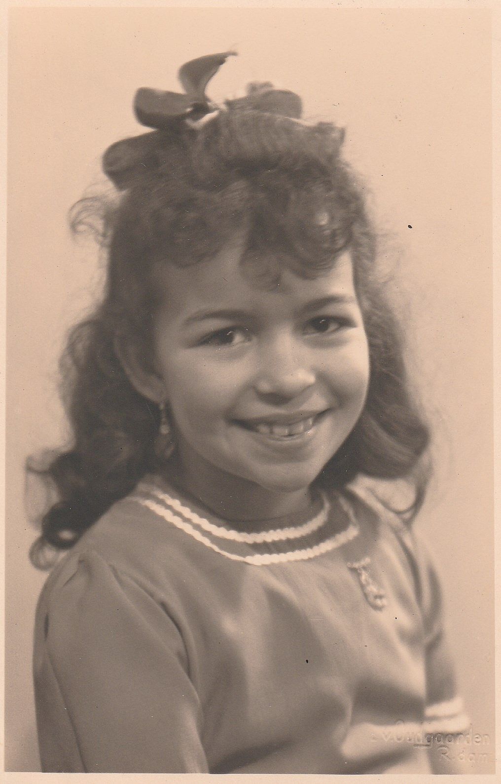 Portrait of Eugènie as a young girl with curly hair and a bow