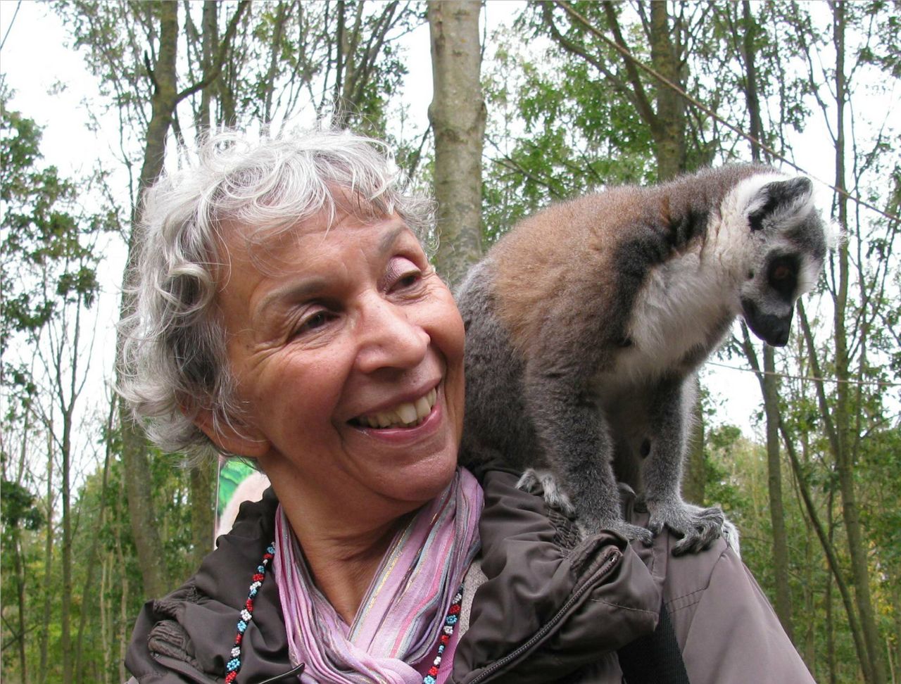 Eugènie Herlaar lachend met een ringstaartmaki op haar schouder