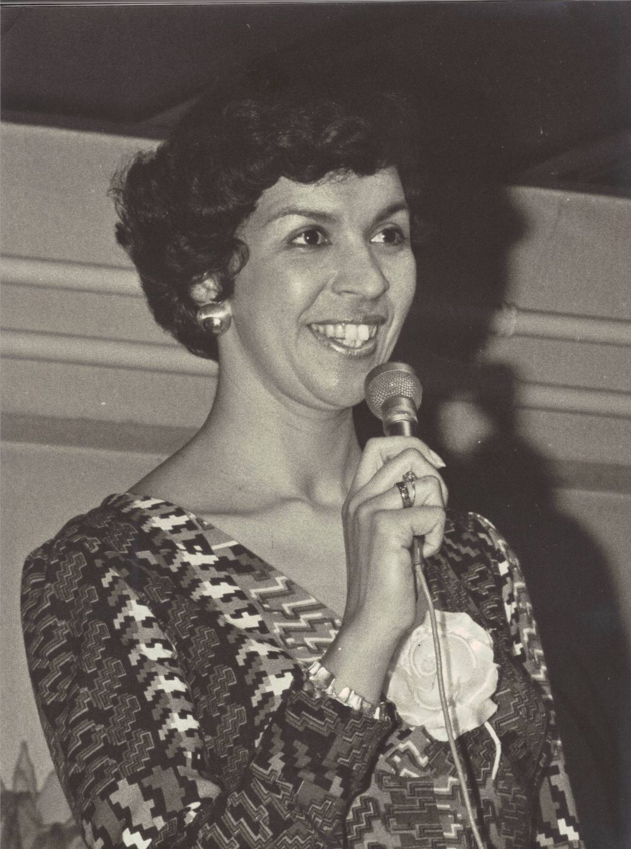 Eugènie presenteert een modeshow met een microfoon in de hand, 1976
